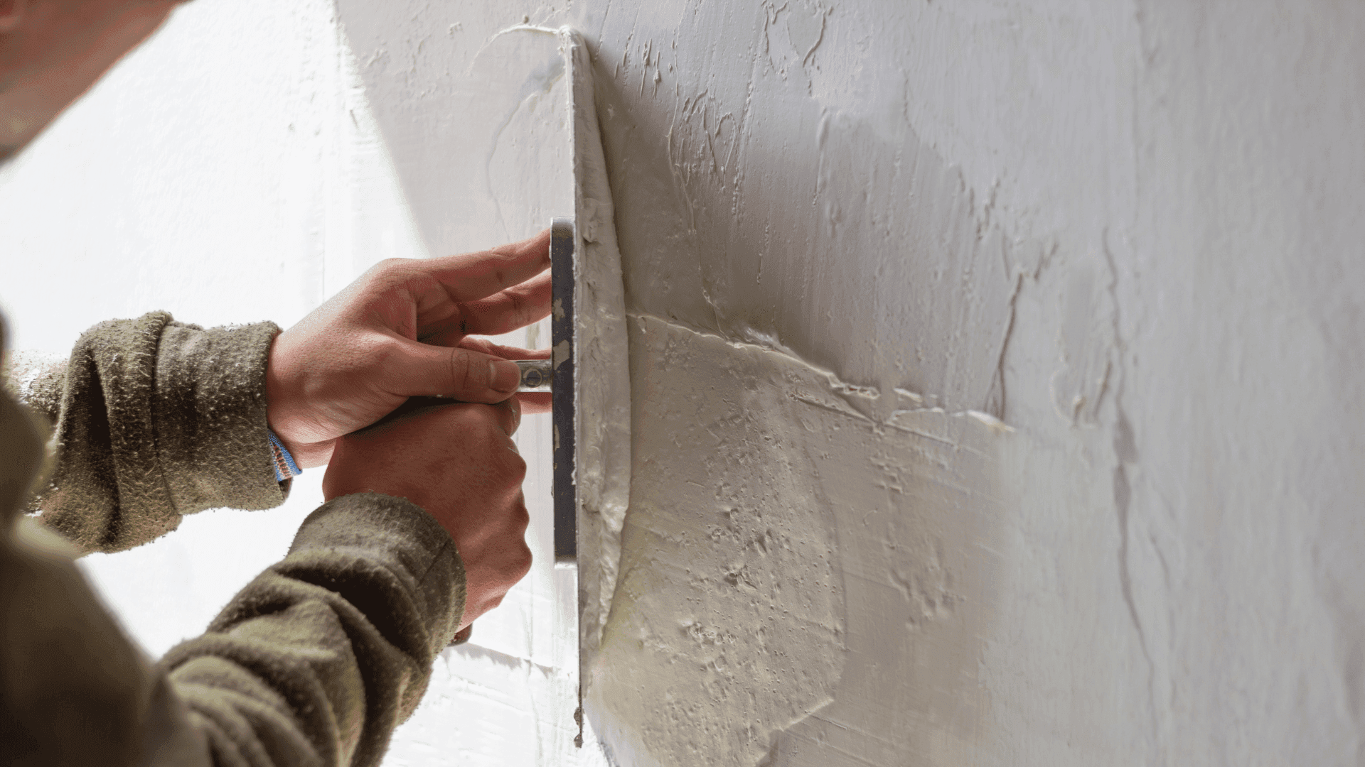 Professionista che sta applicando la malta rasante Natural Calk per la rasatura di un muro.